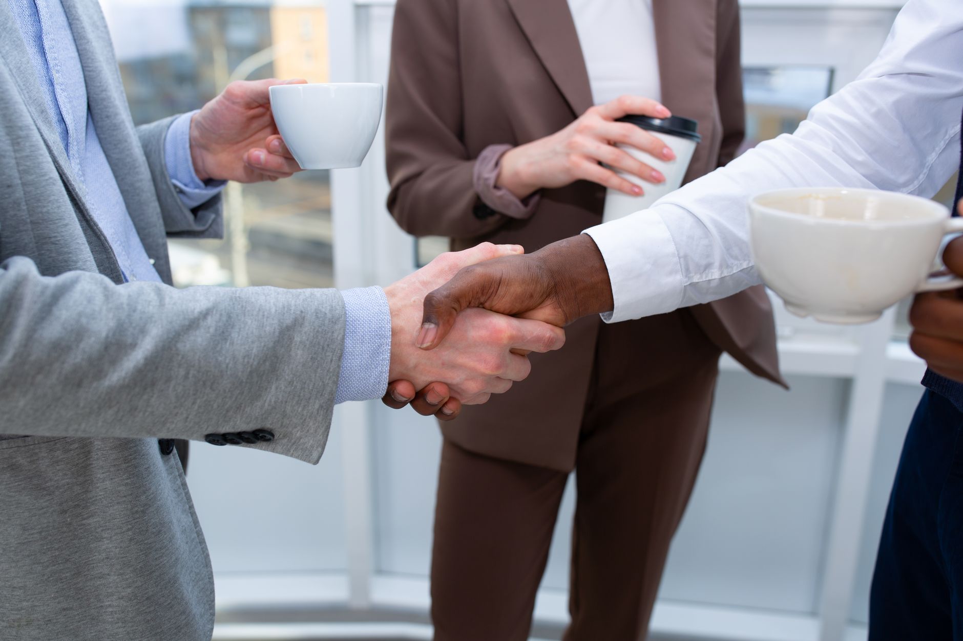 Ejecutivos conversando y estrechando la mano durante una rueda de negocios
